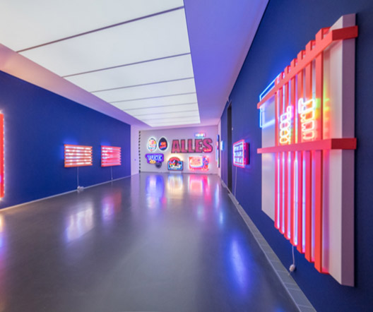 Neon-LED-Installationen in einer modernen Ausstellung mit farbigen Leuchtschriftzügen.