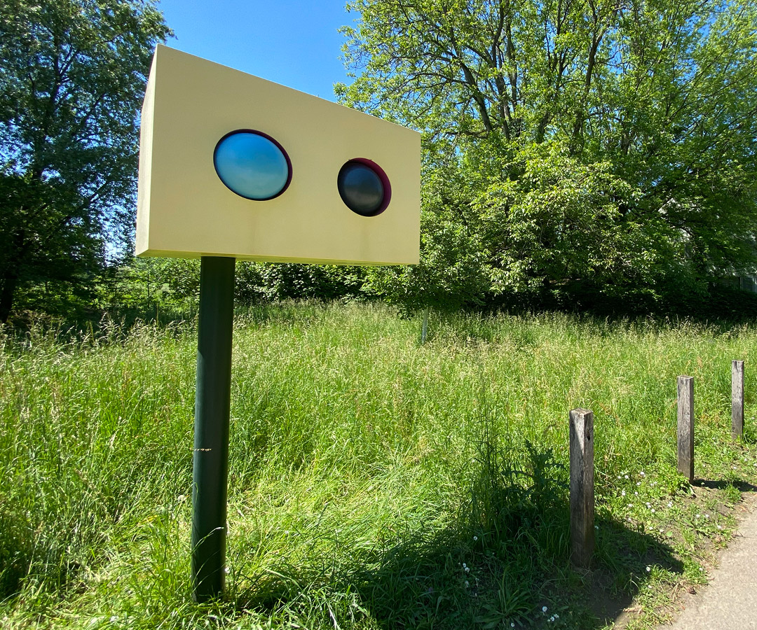 Kunstobjekt am Rehbergerweg aus Edelstahl und Acryl mit Steuerungsmotoren in einer grünen Landschaft