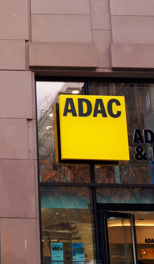 Nahaufnahme des ADAC-Logos auf der Glasfläche über dem Eingangs einer Geschäftsstelle in Frankfurt.