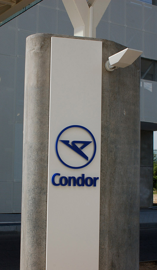 Condor-Logo auf einer freistehenden Säule vor einem Gebäude.