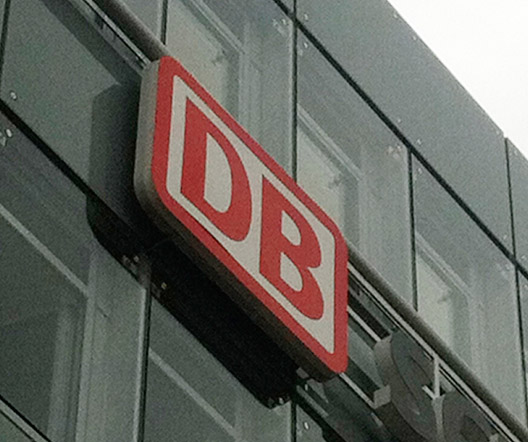 Nahaufnahme des DB-Logos an einer Glasfassade nach der Installation.