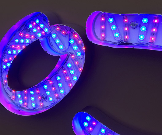 Detailaufnahme der LED-Beleuchtung innerhalb der Moxy Hotels Leuchtschrift, die in Blau und Magenta leuchtet.