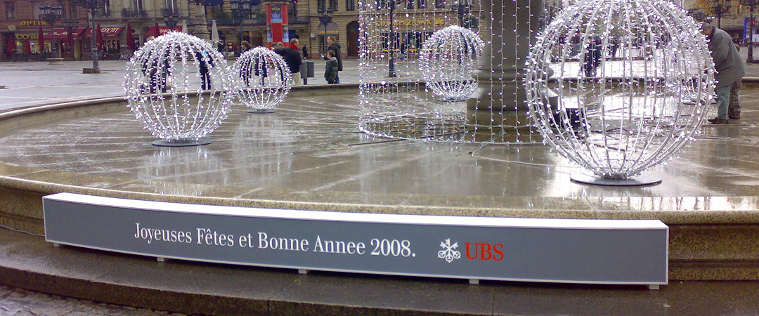 Beleuchteter Brunnen vor der Alten Oper in Frankfurt mit einem französischen Neujahrsgruß von UBS und WISAG für das Jahr 2008.