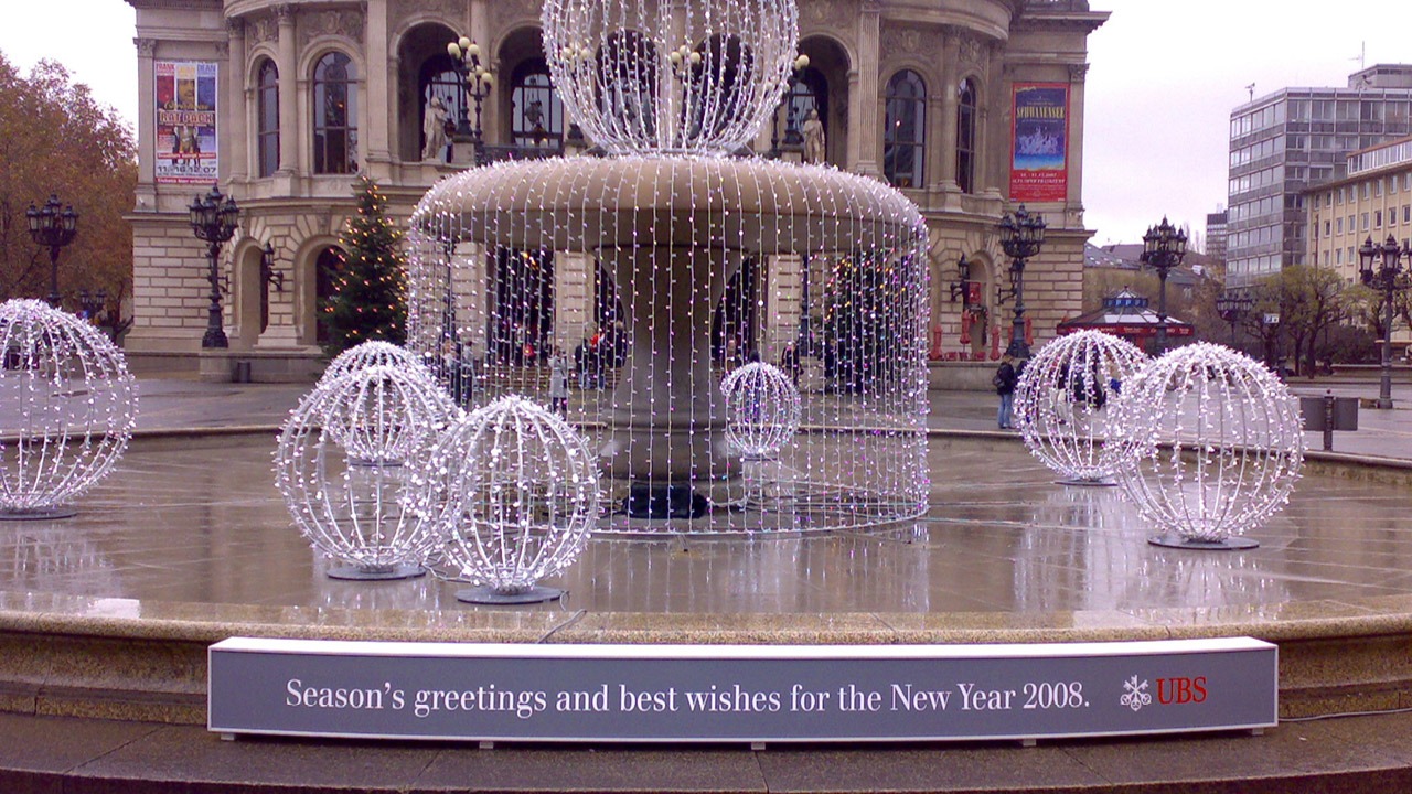 Brunnen vor der Alten Oper in Frankfurt mit festlicher Beleuchtung und einem Neujahrsgruß von UBS und WISAG für das Jahr 2008.