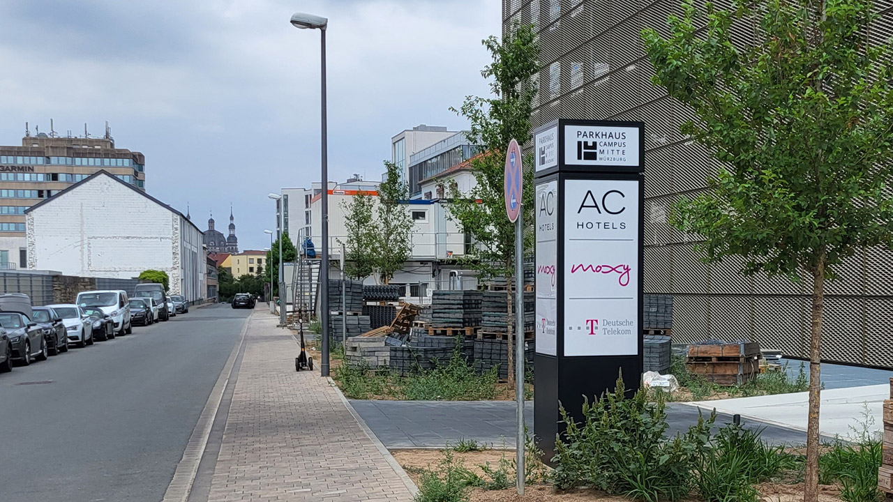 An einer Straße stehende Werbe-Stele für das Parkhaus Campus Mitte in Würzburg.